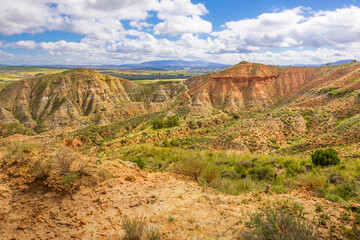 Paisaje Desértico del Geoparque de Granada con Formaciones Geológicas y Cielo Nublado