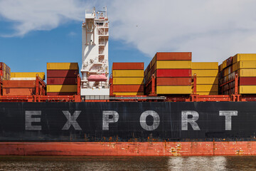 Large container ship loaded with cargo containers docked at a port, with the word EXPORT. concept...