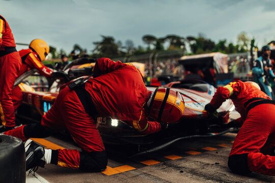 Team Mechanics refuel During a High-Speed Pit Stop in the Midst of an Endurance Race	