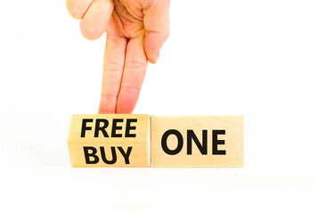 Buy and free one symbol. Businessman turns wooden cubes and changes words Buy one to Free one....