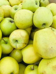 Fresh yellow apples stacked in a market display