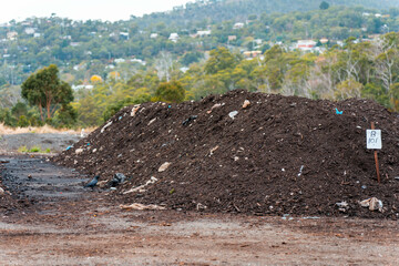turning a compost windrow pile in a community garden. compost full of microorganisms. sustainable...