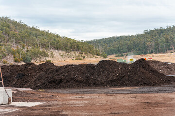 turning a compost windrow pile in a community garden. compost full of microorganisms. sustainable...