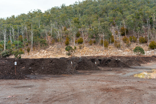 turning a compost windrow pile in a community garden. compost full of microorganisms. sustainable regenerative agriculture. Compost pile, organic thermophilic compost turning in Australia.