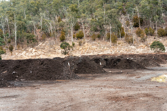 turning a compost windrow pile in a community garden. compost full of microorganisms. sustainable regenerative agriculture. Compost pile, organic thermophilic compost turning in Australia.