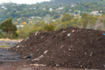 turning a compost windrow pile in a community garden. compost full of microorganisms. sustainable...
