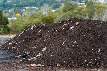 turning a compost windrow pile in a community garden. compost full of microorganisms. sustainable...