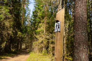 Hiking Trail Sign on Wooden Post.  Close-up of a hiking trail sign mounted on a wooden post in a...