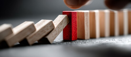 Manager stopping falling wooden dominoes with red block protecting business