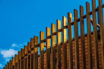 Wooden slats protect the building from sunlight. Decorative wooden facade lathing is an...