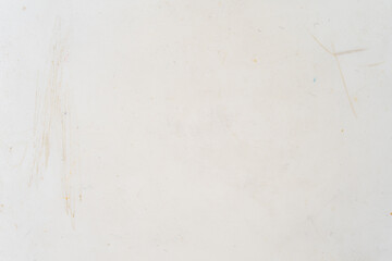 Close-up of a scratched and stained white surface, ideal as a grunge background or texture for design, art, or vintage-themed creative projects.