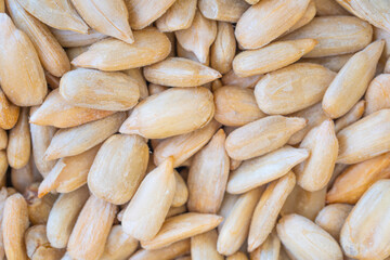 Close-up of shelled sunflower seeds, showcasing their smooth texture and golden hue. Ideal for themes related to healthy snacks, natural foods, and plant-based nutrition.