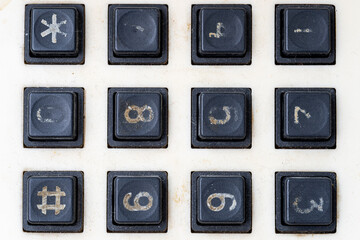 Close-up of a worn-out and dirty numeric keypad with faded numbers and symbols, showing signs of age, heavy use, and vintage or retro technology.