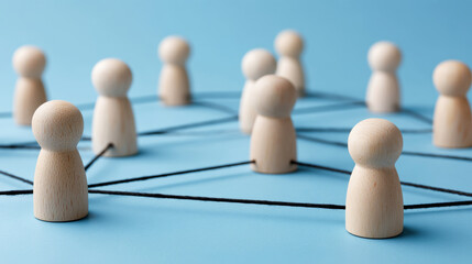 Wooden figures connected by string illustrate concepts of social network, business network, teamwork, communication and partnership