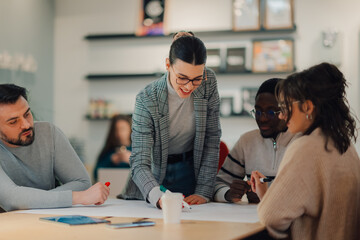 Team leader explaining project to coworkers in modern office