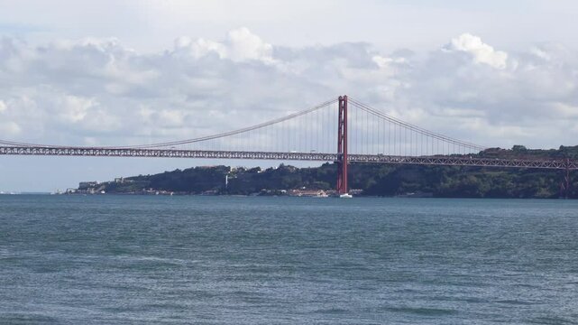 Panoramic view of 25 de Abril Bridge famous tourist landmark of Lisbon connecting Lisboa to Almada on Setubal Peninsula over Tagus river. Lisbon, Portugal