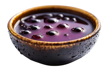 A bowl of rich dark beverage with bubbles and a textured rim perfect for culinary and drink p