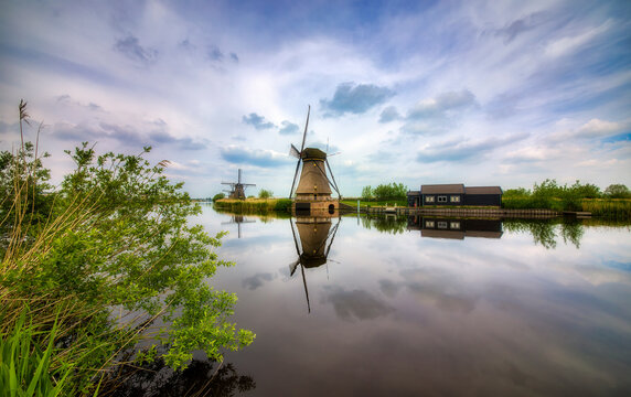 Canal and Old, Charming Windmills Reflecting in the Water in Kinderdijk, Netherlands