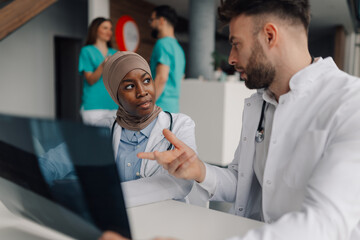 Doctors examining x ray results in hospital meeting room