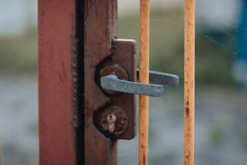 Close-Up of Rusty Metal Gate Handle with Keyhole – Concept of Abandonment and Security