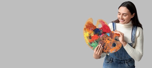 Female artist with palettes on grey background with space for text
