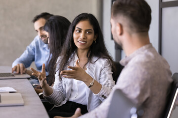 Indian woman engaged in conversation with male colleague, confidently explain point, share ideas,...