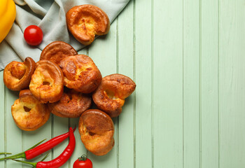 Tasty Yorkshire pudding on green wooden background