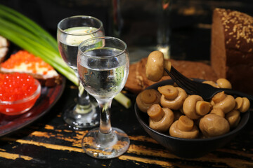 Shots with cold vodka and snacks on dark wooden background