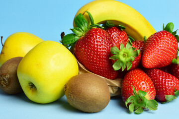 Assorted fruit on a light blue background, healthy food.