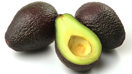 Two whole ripe avocados and one halved avocado showcasing their vibrant green flesh and dark purple skin on a white background.