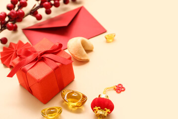 Gift box with envelope, fortune cookie and Chinese symbols on beige background. New Year celebration