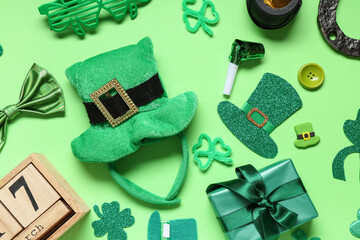 Leprechaun hat with calendar, gift box and decor for St. Patrick's Day on green background