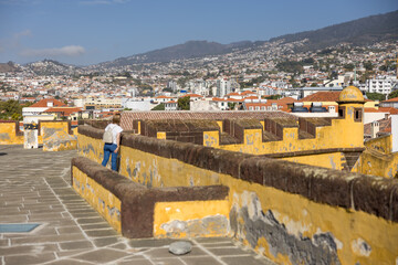 Woman looking to the cityscape of Funchal from Fort of São Tiago. Madeira island, Portugal