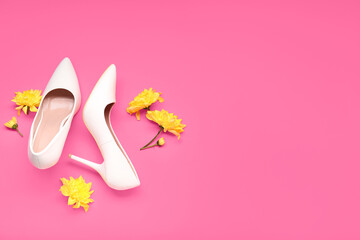 Female high heeled shoes and chrysanthemum flowers on pink background