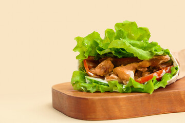Board with tasty doner kebab on beige background, closeup