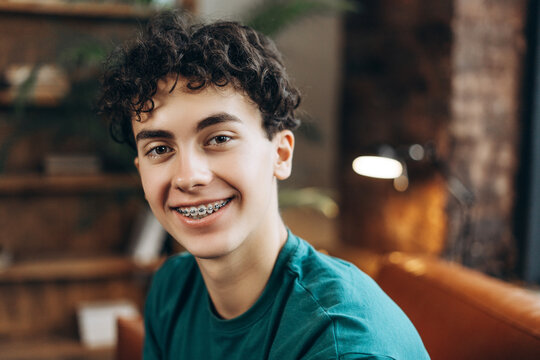 Close up of positive teenage boy with braces wearing t shirt posing at camera - Powered by Adobe