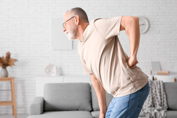 Mature man suffering from back pain at home