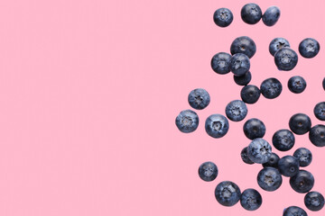 Flying fresh blueberries on pink background