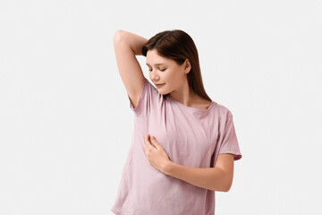 Young woman checking her breast on white background