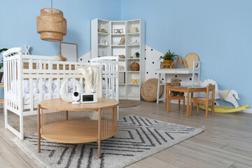 Interior of children's bedroom with bed, toys and baby monitor on table