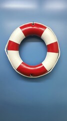 A red and white life preserver hangs against a bright blue background.