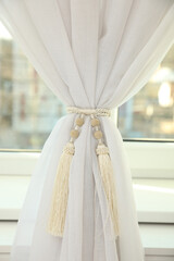Window curtains with stylish tassel tieback indoors