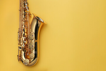 Obraz premium Jazz. One saxophone on yellow background, top view. Space for text