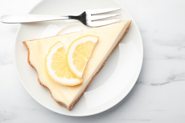 Piece of delicious lemon cheesecake served on white marble table, top view