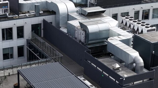 Overhead view of a commercial building rooftop with extensive HVAC ductwork, ventilation systems, and cooling units in an organized layout.