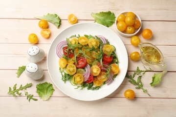 Fresh salad with yellow tomatoes on white wooden table, flat lay