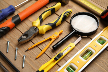 Arrangement of different construction tools on wooden background