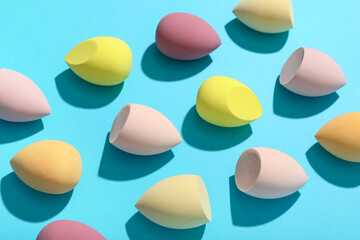 Colorful makeup sponges on blue background