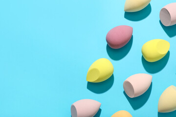 Colorful makeup sponges on blue background