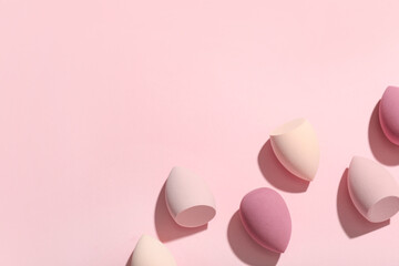 Many makeup sponges on pink background